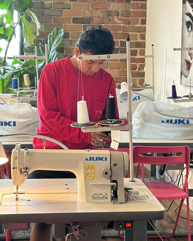 Le Fashion Lab student sewing a garment under instructor supervision, Atlanta