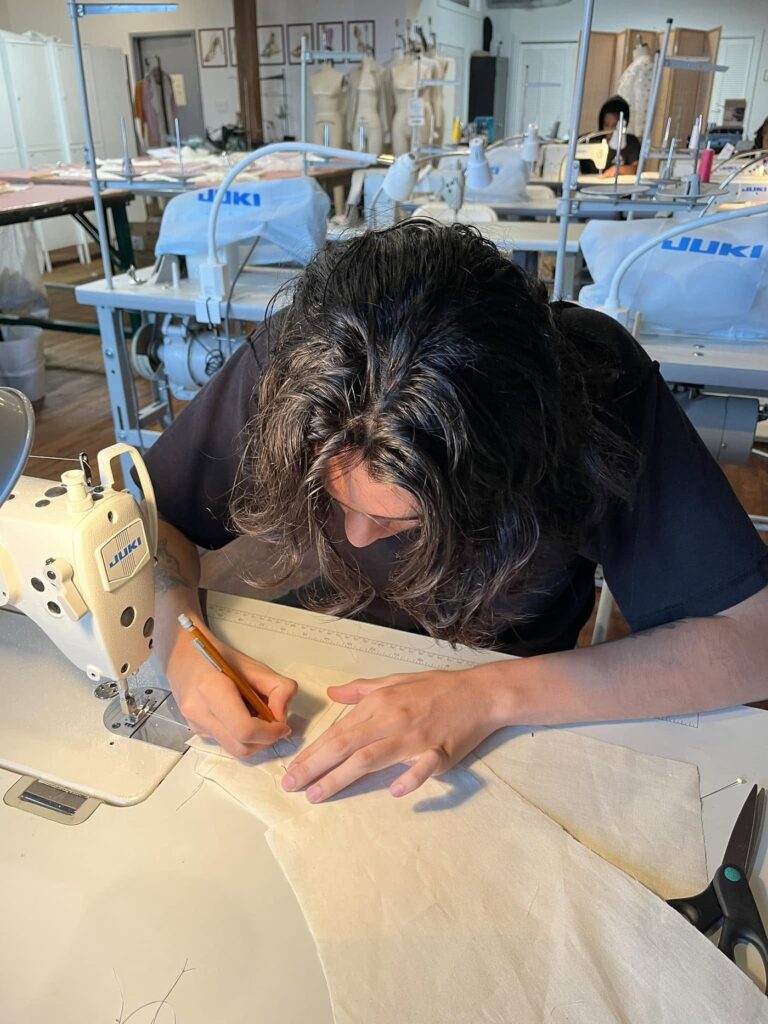 Le Fashion Lab student hand finishing a garment, Atlanta